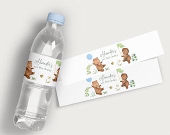 May include: A clear plastic water bottle with a light blue cap and a label featuring a brown bear, a bee, and the text "Alexander's 1st Birthday." Two matching labels are also visible, showcasing the same design.