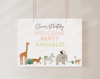 May include: A welcome party sign with the text "Olivia's 1st birthday WELCOME PARTY ANIMALS!" in pink and yellow lettering. The sign features a giraffe, zebra, elephant, and monkey.