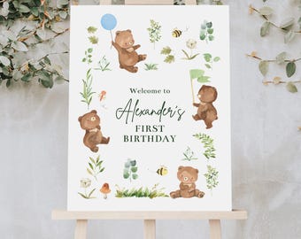 May include: Welcome to Alexander's First Birthday sign with a white background and watercolor illustrations of bears, bees, and flowers.