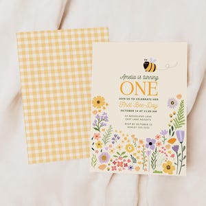 Puede incluir: Una tarjeta con un patr&oacute;n de cuadros vichy amarillo y blanco con un dise&ntilde;o de abeja y flores. La tarjeta dice "Amelia cumple UN A&Ntilde;O" y "&Uacute;nete a nosotros para celebrar su primer d&iacute;a de abeja". La tarjeta tambi&eacute;n incluye la fecha, la hora, la ubicaci&oacute;n, la informaci&oacute;n de RSVP y la informaci&oacute;n de contacto.
