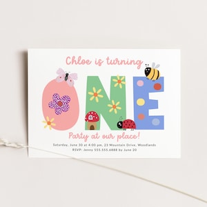 May include: A colorful invitation for a first birthday party. The invitation features the word "ONE" in large, colorful letters decorated with flowers, a ladybug, a butterfly, a bee, and a mushroom house. The text reads "Chloe is turning ONE. Party at our place! Saturday, June 30 at 4:00 pm, 23 Mountain Drive, Woodlands. RSVP: Jenny 555.555.6888 by June 20."