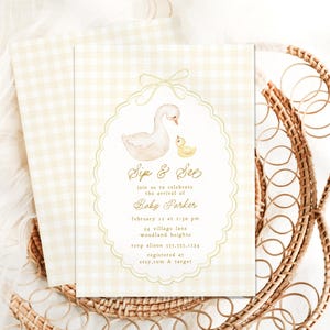 May include: A white and yellow baby shower invitation with a watercolor illustration of a swan and a duckling. The invitation reads "Sip & See" and includes the baby's name, date, time, and location. It also includes RSVP information and where the baby is registered.