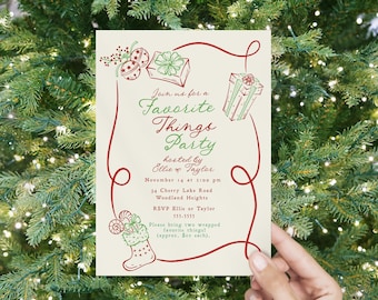 May include: A cream-coloured invitation for a "Favorite Things Party" with red and green illustrations of gifts and a stocking. The text includes the party details: date, time, location, and RSVP information. The invitation is held against a backdrop of a Christmas tree.