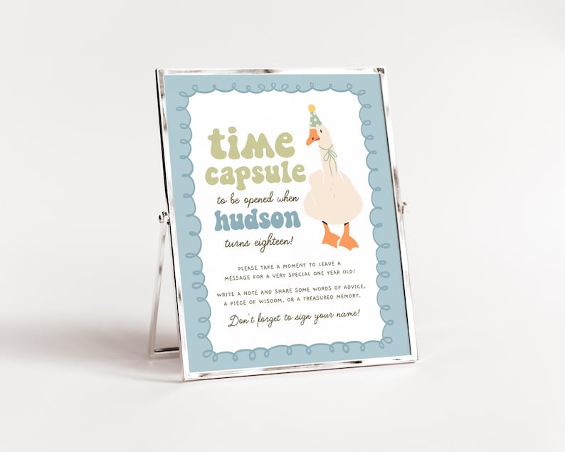 May include: A blue and white sign with a goose wearing a party hat. The sign says "time capsule to be opened when hudson turns eighteen!" Please take a moment to leave a message for a very special one year old! Write a note and share some words of advice, a piece of wisdom, or a treasured memory. Don't forget to sign your name!"