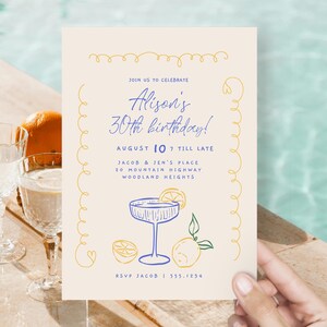 May include: A light beige invitation card with yellow and blue illustrations. The text on the card reads "Join us to celebrate Alison's 30th birthday! August 10 7 till late Jacob & Jen's Place 20 Mountain Highway Woodland Heights RSVP Jacob | 555.1234"