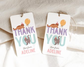 Könnte beinhalten: Zwei Dankeschön-Etiketten mit einem Katzen- und Ballon-Design. Der Text auf den Etiketten lautet "Danke" in lila und blauer Schrift mit den Worten "Liebe von, Adeline" in rosa Schrift.
