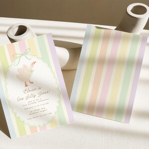 May include: A pastel striped invitation card with a cute illustration of a goose. The text on the card reads "Elise is One Silly Goose!" and includes details for a first birthday celebration.