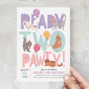 Op de afbeelding: Een roze en paarse verjaardagsuitnodiging met de tekst "Ready Two Pawty!" en illustraties van katten met ballonnen. De uitnodiging is voor een 2e verjaardagsfeestje voor Adeline. De datum is 10 september om 14:00 uur. Het adres is 33 Woodland Drive, Jackson Valley. RSVP v&oacute;&oacute;r 10 september aan Jessie 555.12.