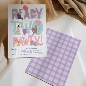 May include: A birthday party invitation with the words "READY TWO PAWTY!" and illustrations of cats and dogs. The invitation is white with a purple and pink color scheme. The back of the invitation has a purple and white checkered pattern.