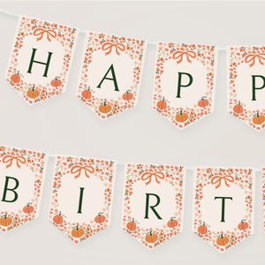 May include: A decorative banner spelling "HAPPY BIRTH". Each pennant has a cream background with floral and pumpkin designs. The letters are dark green, and the banner is strung on a white string, ideal for a birthday party.