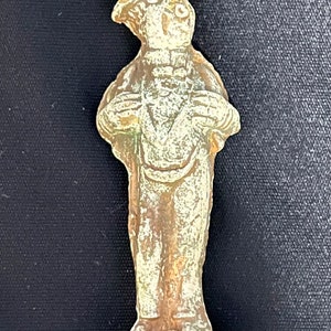 May include: A small, detailed, ceramic figurine of a man wearing a top hat and a suit. The figurine is painted in shades of brown and white.