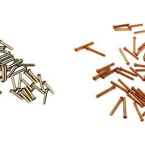May include: A pile of gold-colored metal rivets and a pile of copper-colored metal rivets.
