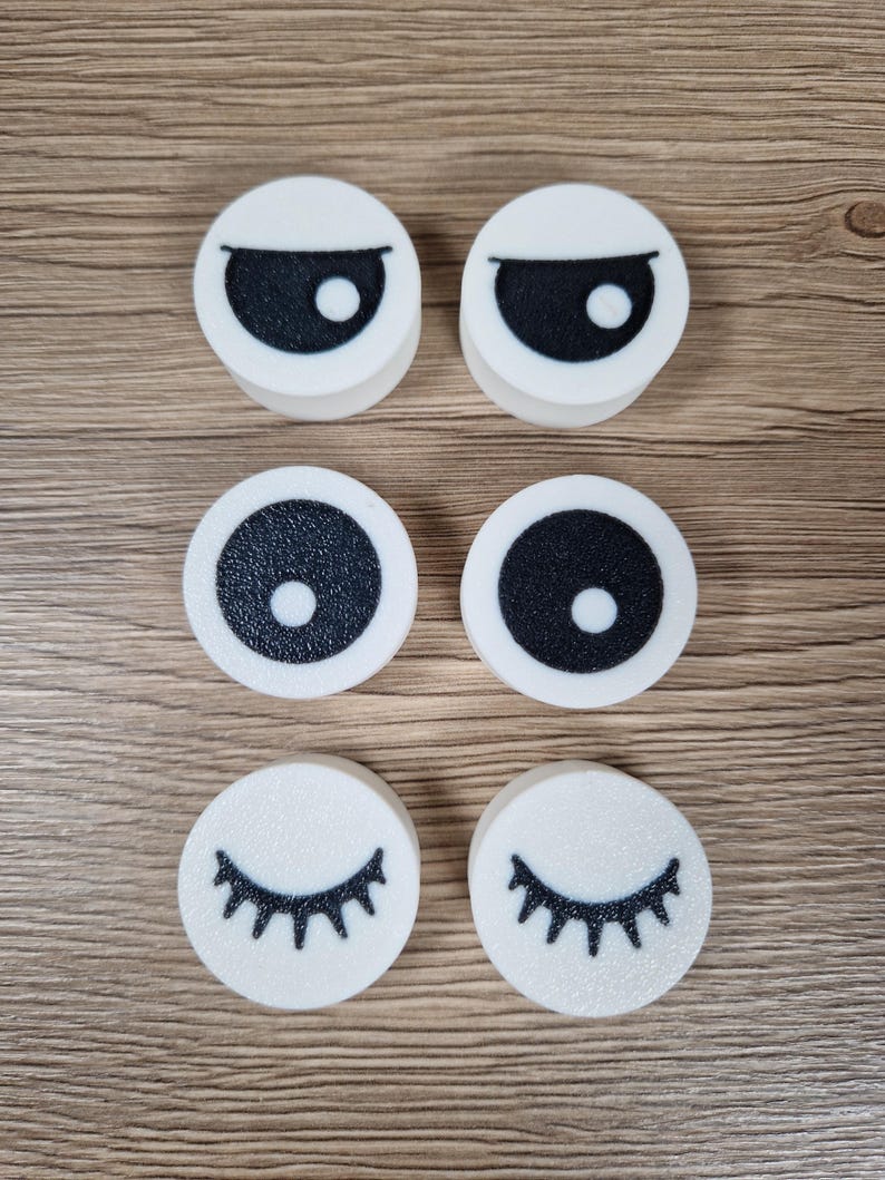 Puede incluir: Seis recortes de espuma blancos y circulares con dise&ntilde;os de ojos negros. Dos recortes tienen cejas negras y formas de ojos, dos tienen c&iacute;rculos negros con puntos blancos y dos tienen pesta&ntilde;as negras.