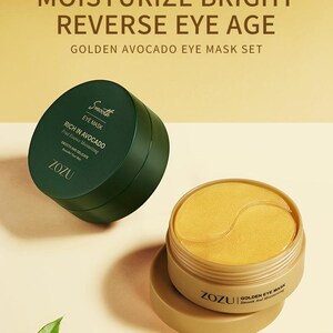 May include: A set of golden avocado eye masks in a gold container with a green container of eye mask cream. The text on the containers reads "ZOZU Golden Eye Mask Smooth and Moisturizing" and "Smooth Eye Mask Rich in Avocado Fruit Essence Moisturizing Smooth and Delicate ZOZU". The image also includes four icons representing the benefits of the eye masks: fade fine lines, firm lifting, fade eye circles, and soothing pouch.