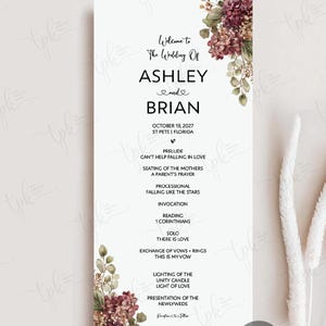 May include: A vertical wedding program card with a white background, featuring floral illustrations of burgundy and green hydrangeas in the top right and bottom left corners. The text includes the names Ashley and Brian, date, and ceremony order.