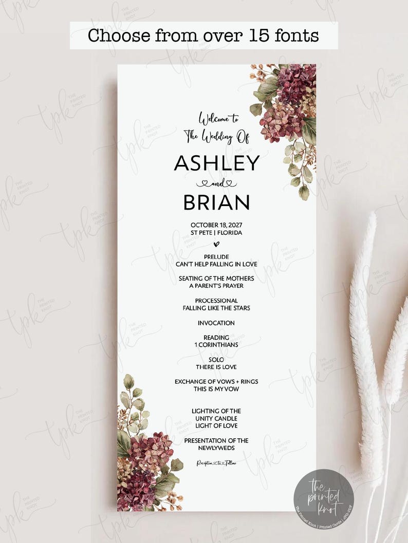 May include: A vertical wedding program card with a white background, featuring floral illustrations of burgundy and green hydrangeas in the top right and bottom left corners. The text includes the names Ashley and Brian, date, and ceremony order.