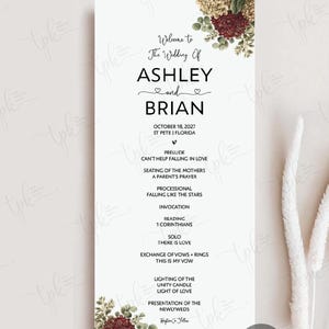 May include: A vertical wedding program card with a white background, featuring floral illustrations of red and cream hydrangeas at the top and bottom. The text reads: Welcome to The Wedding Of ASHLEY and BRIAN, October 18, 2027, St Pete, Florida, and ceremony details.