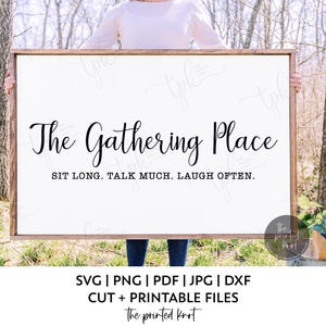 May include: A rectangular wooden sign with the text "The Gathering Place" in elegant script. Below, the sign reads "SIT LONG. TALK MUCH. LAUGH OFTEN." The sign is held by a person outdoors, with trees in the background. The sign is a printable file.