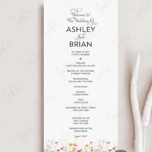 May include: A vertical white wedding program card featuring black text detailing the ceremony order for Ashley and Brian on October 18, 2027, in St. Pete, Florida. The bottom edge is decorated with a colorful watercolor illustration of wildflowers.