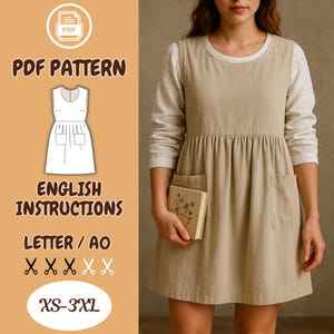 May include: A tan pinafore dress with two front pockets and a gathered waist is shown. The dress is worn over a white long-sleeved shirt. The image also includes a PDF pattern graphic with the text "PDF PATTERN", "ENGLISH INSTRUCTIONS", and size range "XS-3XL".