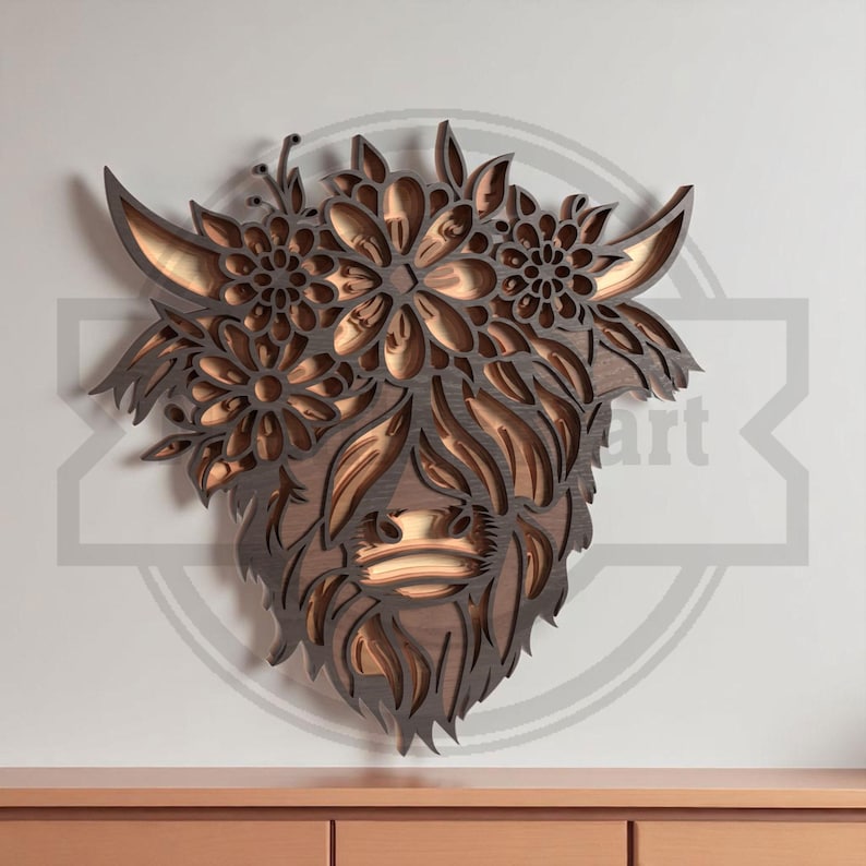 Puede incluir: Una pieza de arte mural de madera en capas que representa la cabeza de una vaca de las Highlands, adornada con elementos florales. La obra de arte presenta un dise&ntilde;o detallado en tres dimensiones con diferentes tonos de marr&oacute;n y beige, creando una est&eacute;tica r&uacute;stica y natural.