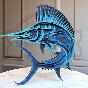 May include: A layered wooden sculpture of a marlin fish in shades of blue. The artwork features intricate details, including the fish's long bill, fins, and textured body. The sculpture is displayed on a white surface, showcasing the depth and dimension of the design.