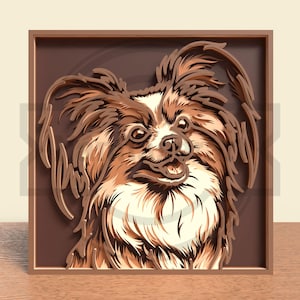 May include: A layered wooden art piece featuring a Papillon dog. The artwork showcases the dog's face with detailed fur in shades of brown, cream, and white, set against a dark brown background within a framed border. The dog's expression is friendly.
