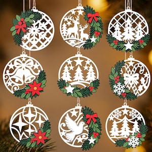 Può includere: Un set di nove ornamenti circolari bianchi con intricati ritagli di fiocchi di neve, cervi, pini, campane, bastoncini di zucchero, stelle e una colomba. Ogni ornamento è decorato con rami di pino verdi, bacche rosse e fiocchi rossi.