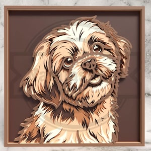 Op de afbeelding: Een gelaagd papieren kunstwerk met een lachende hond met bruine en crèmekleurige vacht. Het gezicht van de hond heeft gedetailleerde ogen en een getextureerde neus. Het kunstwerk is geplaatst in een bruine lijst, waardoor een 3D-effect ontstaat.