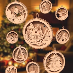 May include: A collection of wooden Christmas ornaments with intricate laser-cut designs. Each ornament features a different winter scene, including houses, trees, and religious figures. The ornaments are round with a small loop for hanging.