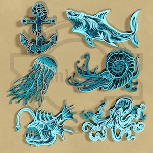 Puede incluir: Colección de arte en papel en capas con vida marina. Incluye una ancla, un tiburón, una medusa, un nautilus, un rape y un pulpo. La obra de arte está en tonos de azul y turquesa, con detalles intrincados y un tema náutico.