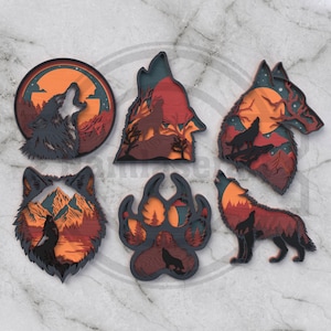 Puede incluir: Colección de seis diseños de lobos de madera en capas. Cada pieza presenta un lobo aullando contra un fondo de puesta de sol, montañas o una huella de pata. La paleta de colores incluye tonos de naranja, rojo y gris.