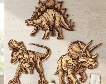 May include: Three wooden dinosaur wall art pieces: a Stegosaurus, a Tyrannosaurus Rex, and a Triceratops. The dinosaurs are in shades of brown and tan, mounted on a light-colored wall. A small framed picture and a potted plant are on a wooden surface.