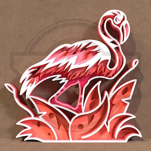 May include: A layered paper art piece depicting a flamingo in pink, white, and red hues. The flamingo is set against stylized leaves, with a brown backdrop. The artwork has a 3D effect, creating depth and dimension.