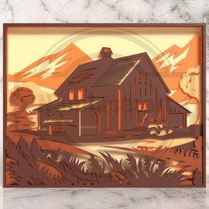 May include: A layered paper art piece depicting a barn in a rural landscape. The artwork features a brown barn with a detailed roof, set against a backdrop of orange mountains and a yellow sky. The foreground includes stylized grass and trees, all within a brown frame.