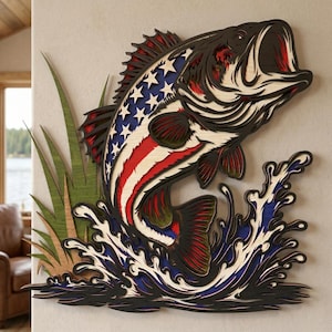 May include: A layered wooden wall art piece depicting a largemouth bass leaping out of water. The fish is colored with the American flag design, featuring red and white stripes, blue stars, and a black outline. Green grass and blue water complete the patriotic scene.