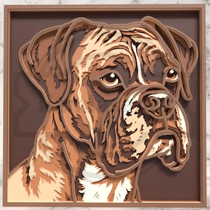 Puede incluir: Una obra de arte en papel multicapa que representa la cabeza de un Boxer en varios tonos de marrón y beige. El efecto 3D se logra mediante capas de papel, creando profundidad. Los rasgos del perro son detallados y la obra está enmarcada.