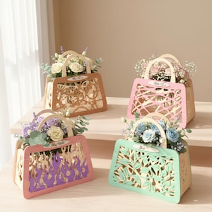 May include: Four decorative wooden purse-shaped flower boxes, each filled with flowers. The boxes are in shades of tan, pink, purple, and green, with intricate cut-out designs. Each box has a handle and a small label with text.