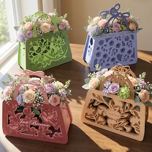 Può includere: Quattro composizioni floreali decorative in legno a forma di borse. Le borse sono nei toni del verde, blu, rosa e legno naturale. Ogni borsa è riempita con un assortimento di fiori dai colori pastello, tra cui rose e ortensie. La borsa rosa ha il testo "Just Because".