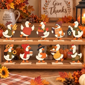 May include: A set of ten wooden duck figurines arranged on a two-tiered wooden shelf. Each duck features autumn-themed accessories including pumpkins, sunflowers, scarves, hats, books, lanterns, and coffee cups, all painted in warm seasonal colors.