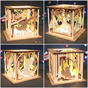 May include: A wooden, illuminated box with laser-cut designs. The box features patriotic themes, including an eagle, the Statue of Liberty, flags, and the words "Liberty" and "America". The box is lit from within, creating a warm glow.
