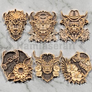 May include: Six layered wooden art pieces featuring detailed animal faces, including a bison, a bull with a cowboy hat, and a bull with floral accents. The pieces are in shades of brown and tan, with intricate cut-out designs.