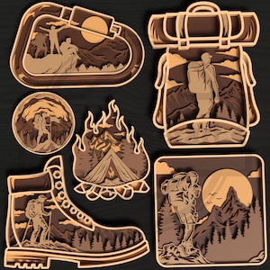 Può includere: Una collezione di ritagli di legno a strati con temi di avventura all'aperto. I disegni includono un escursionista su una montagna, un falò con una tenda, uno scarponcino da trekking, uno zaino e un moschettone, in tonalità marroni e beige.