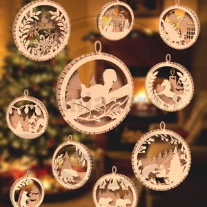 May include: A collection of nine wooden Christmas ornaments with various nature-themed cut-out designs. Each ornament is circular with a small loop for hanging. Designs include animals, trees, and winter scenes, all in natural wood tones.