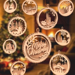 May include: A collection of wooden Christmas ornaments with various designs. Each ornament is circular with a detailed cutout scene, including a reindeer, a forest, a candle, and the text "Merry Christmas".