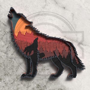 May include: A layered wooden artwork showing a howling wolf silhouette against a sunset. The piece features a wolf, trees, and a gradient of orange, red, and blue. The wolf is black with a detailed, layered design, creating a 3D effect.