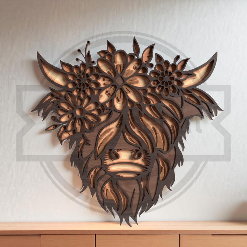 Puede incluir: Arte de pared de madera que representa la cabeza de una vaca de las Tierras Altas con detalles florales. El dise&ntilde;o en capas crea un efecto tridimensional con tonos de madera natural y elementos florales detallados. La cara de la vaca est&aacute; enmarcada por una corona floral.