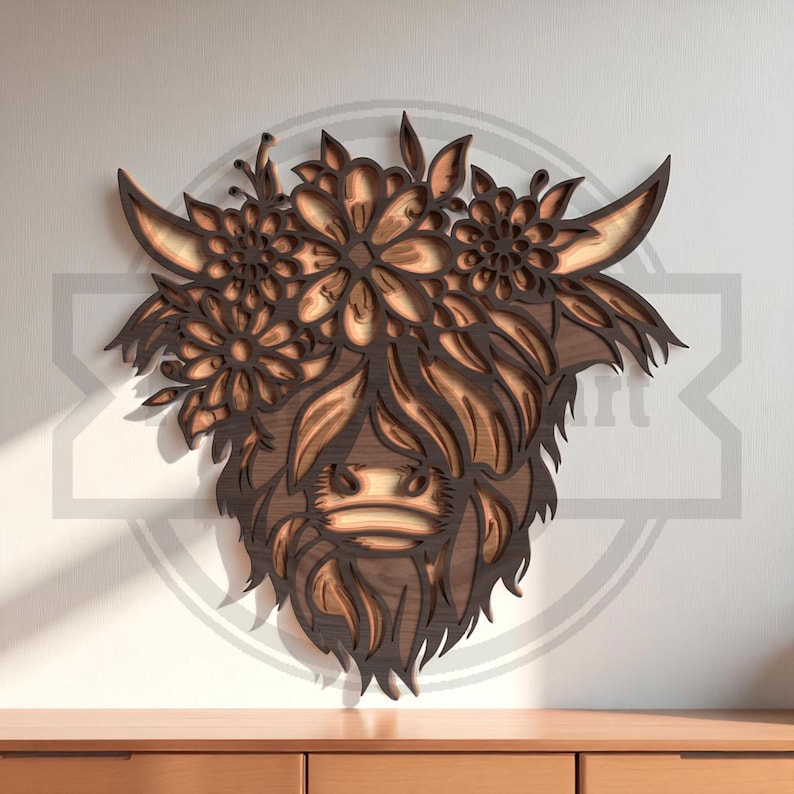 Puede incluir: Arte de pared de madera que representa la cabeza de una vaca de las Tierras Altas con una corona floral. La obra de arte est&aacute; hecha de madera en capas, mostrando un dise&ntilde;o detallado con diferentes tonos de marr&oacute;n. La vaca tiene pelo largo y cuernos curvados, y las flores est&aacute;n intrincadamente talladas.
