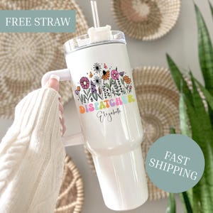 May include: White insulated tumbler with a handle, featuring a floral design and the word "DISPATCHER" in colorful letters. The name "Elizabeth" is printed below the word. A clear straw is inserted into the lid.