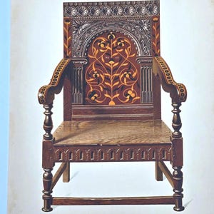 May include: An antique wooden chair with a high back and armrests. The chair features intricate carvings and inlaid designs in shades of brown and orange. The back of the chair has a decorative arch design. The chair is a vintage piece of furniture.